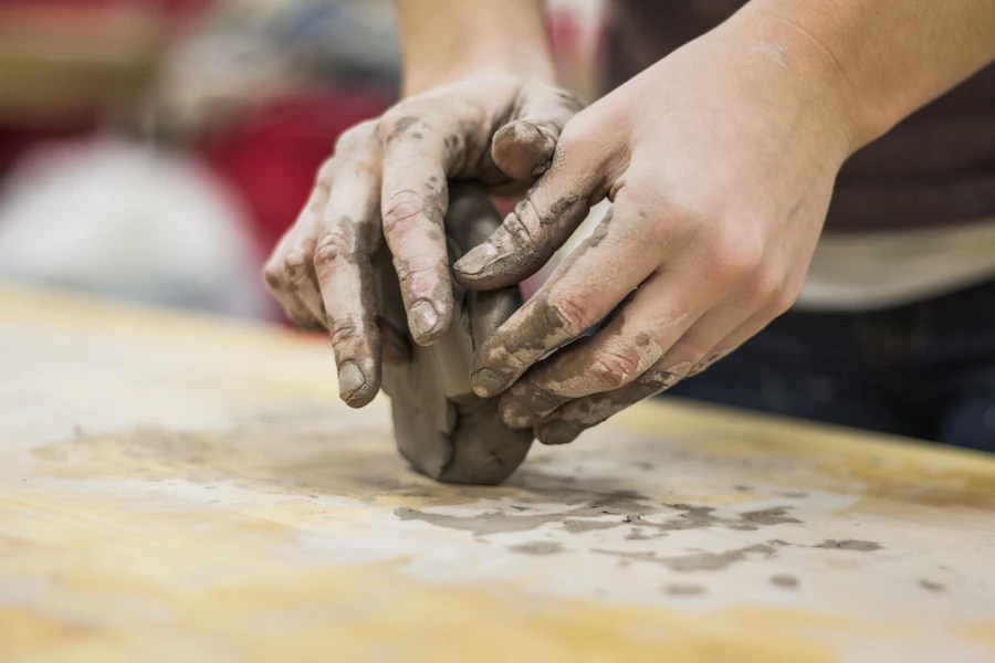 Wedging clay on the bench